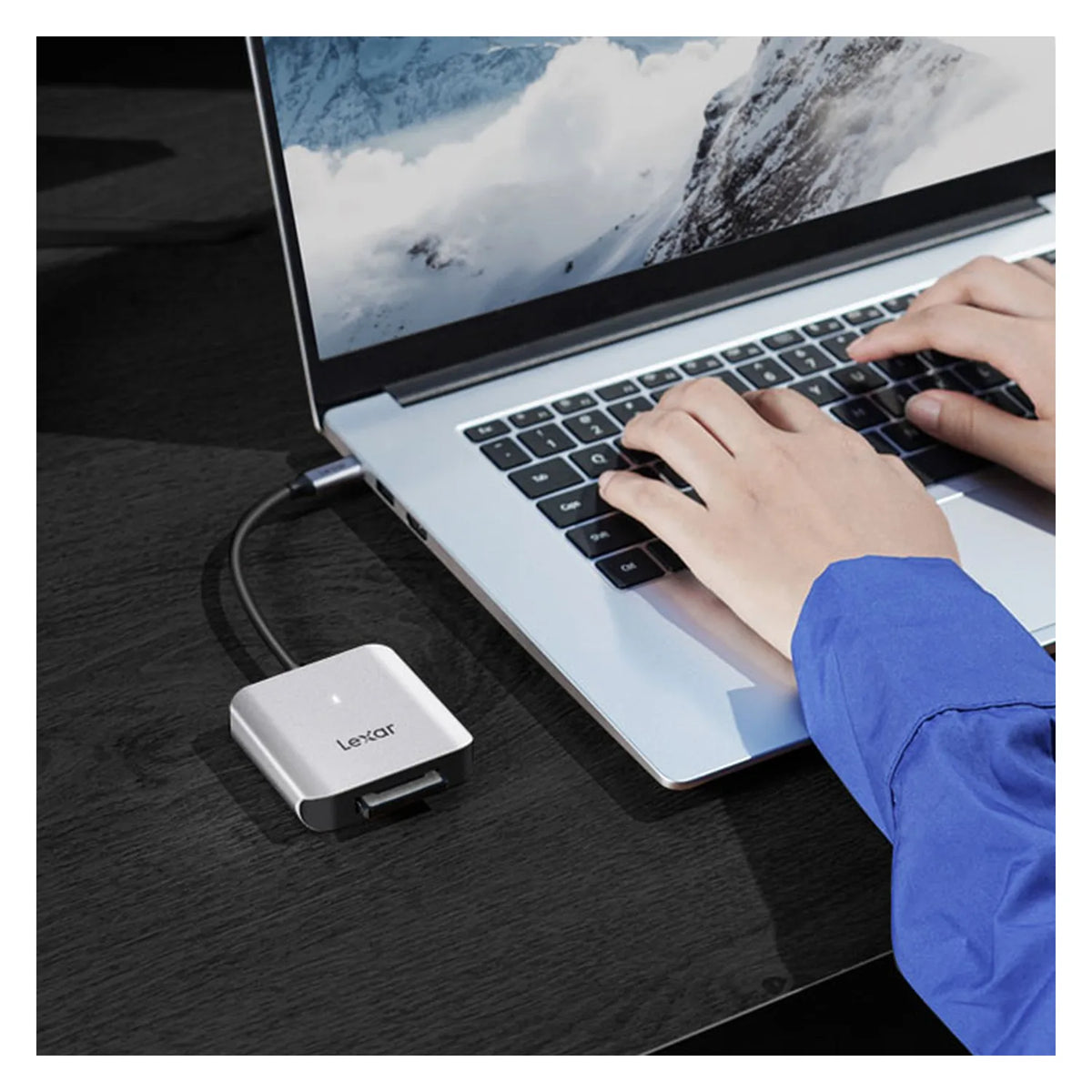 CFexpress card reader connected to laptop via USB-C, silver-gray housing