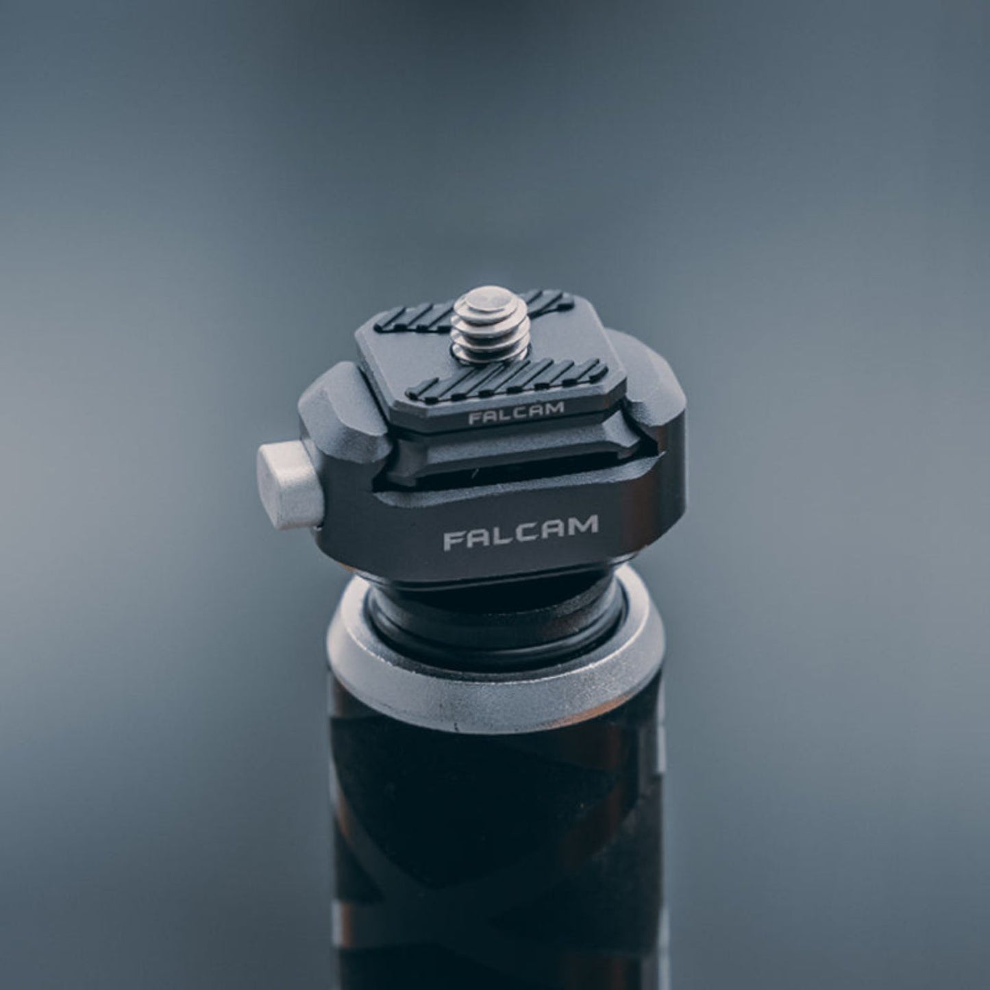 Camera quick release base with white screw knob and rotating plate, dark gray