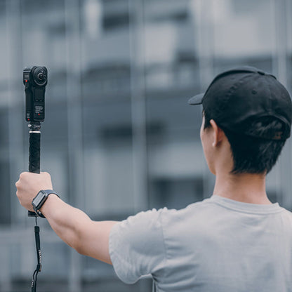Camera quick release mount on a handheld pole with camera attached, dark gray
