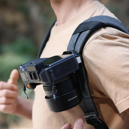 F38 quick release camera backpack strap clip attached to dark strap on a person