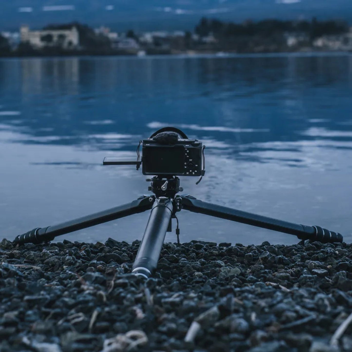 Tripod with mounted camera, black carbon-fiber legs and adjustable center column