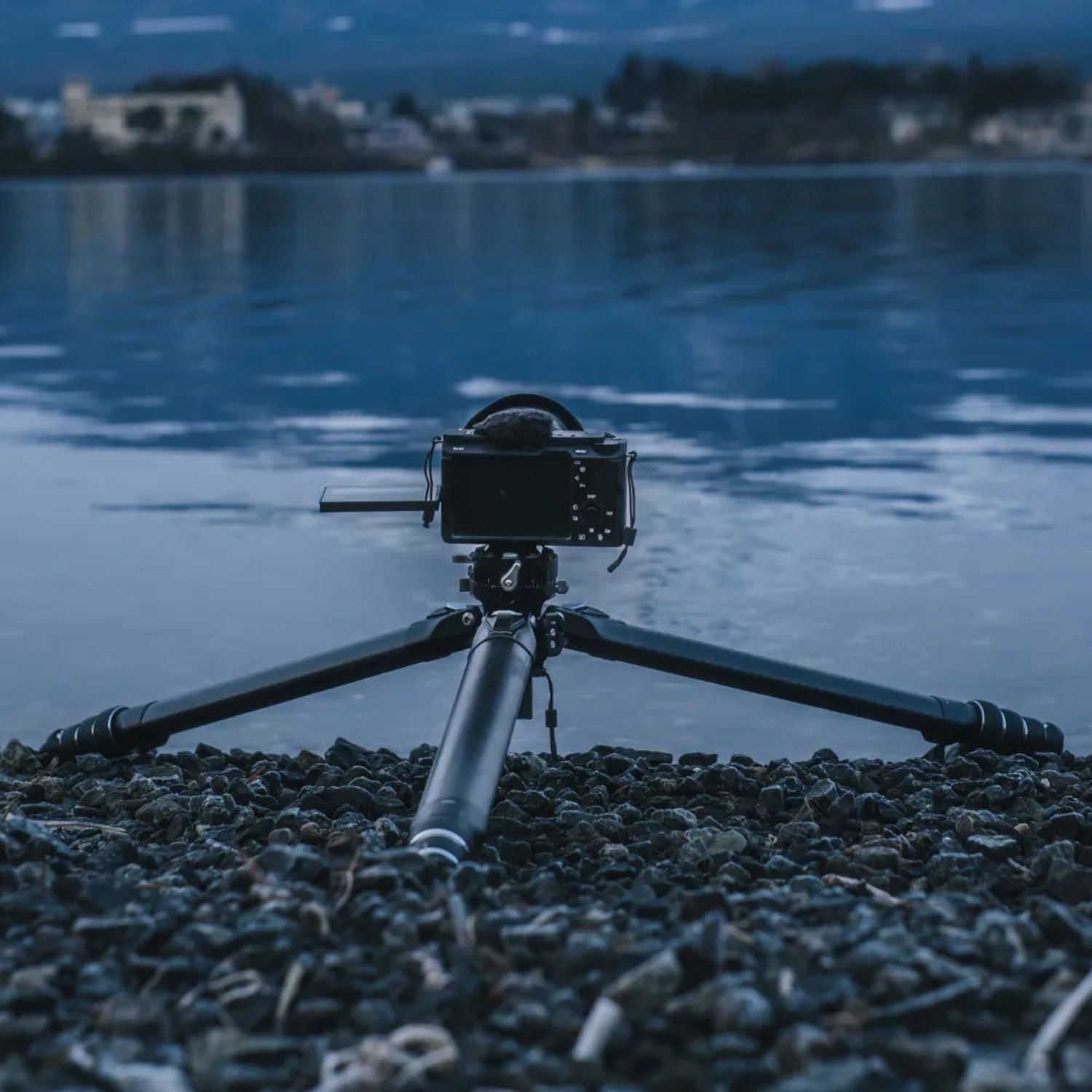 Tripod with mounted camera, black carbon-fiber legs and adjustable center column