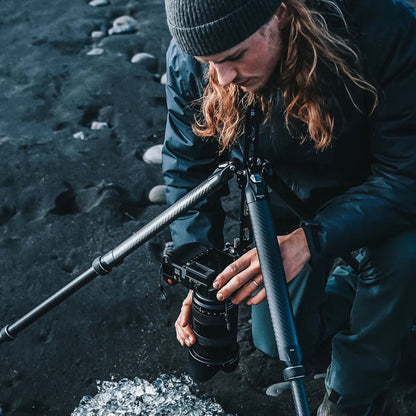 Tripod with mounted camera and central column, black carbon-fiber legs