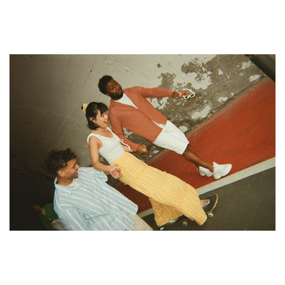 Printed photo showing four people indoors in colorful casual clothes