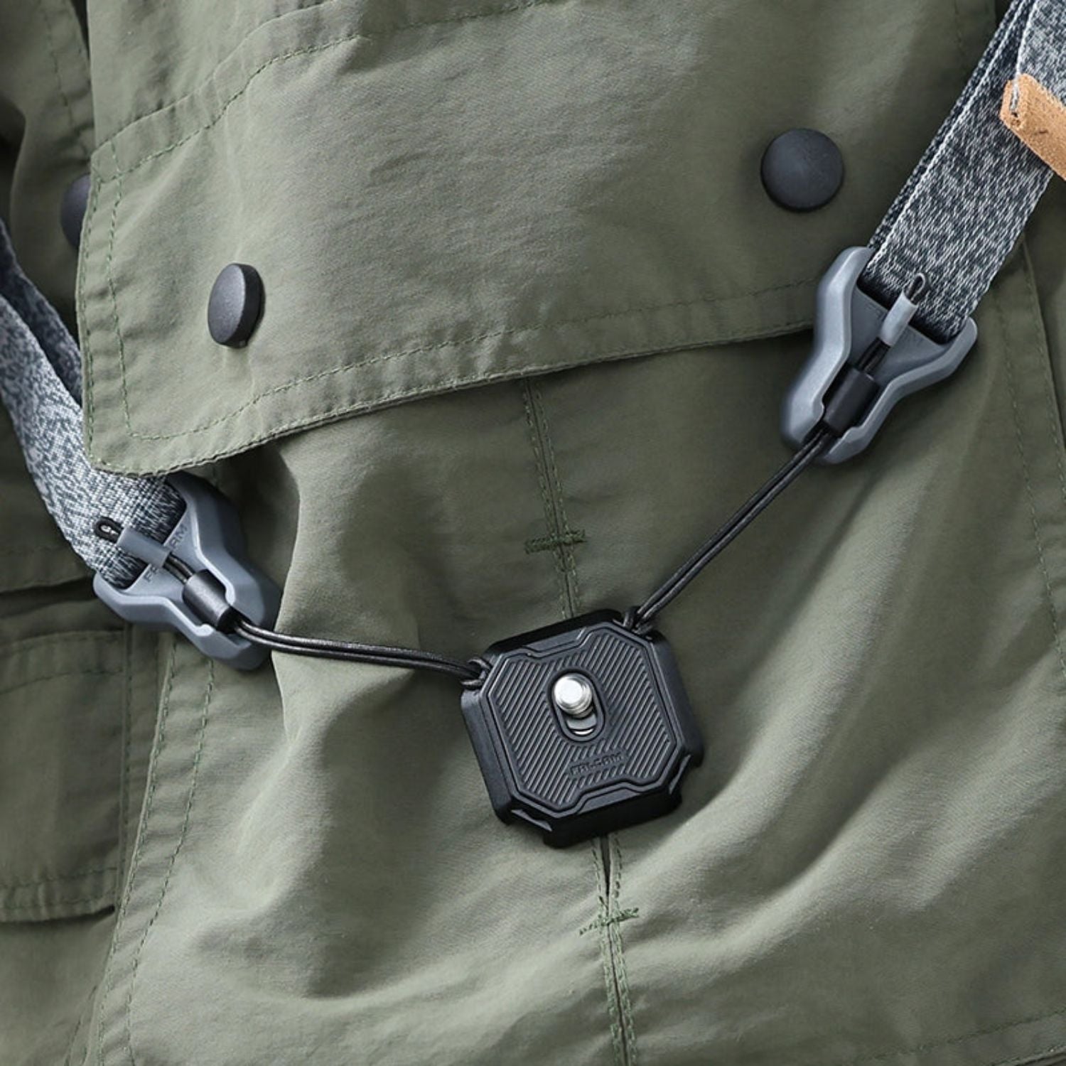 Non-slip quick release plate attached to green fabric with strap lanyard