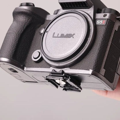 Camera quick release plate with textured grip and mounting slot, black metal
