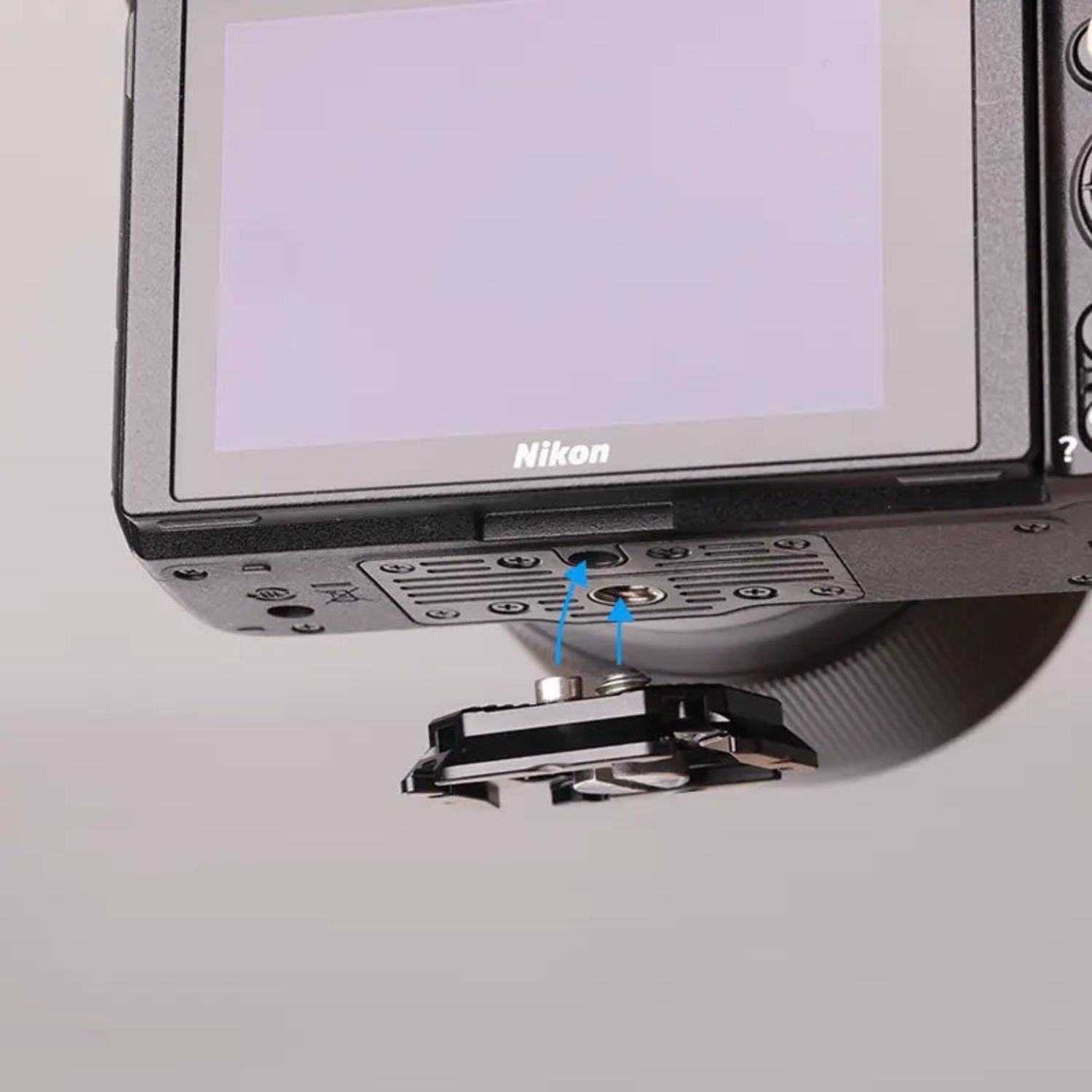Quick release plate on camera base with two metal pins, black mounting frame