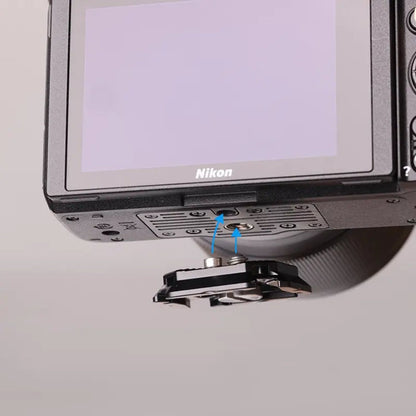 Quick release plate on camera base with two metal pins, black mounting frame