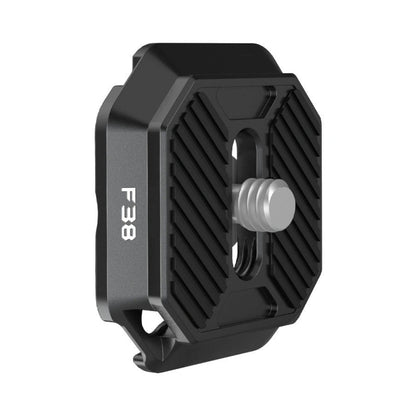 Quick release plate, dark gray metal with spring-loaded screw and ridged grip edges